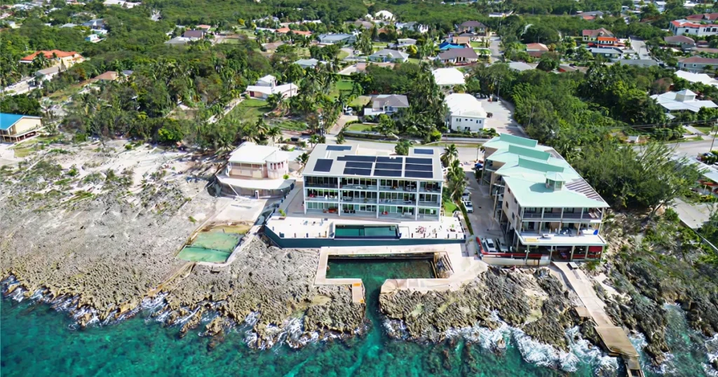 Aerial view of a luxury waterfront investment property in the Cayman Islands with an infinity pool.